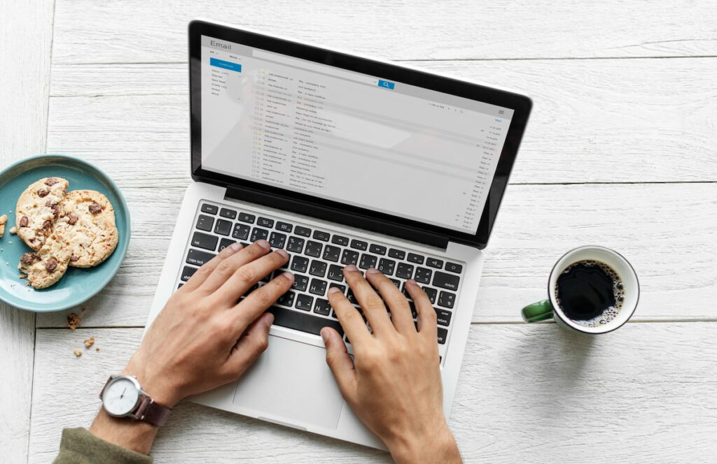 man using a laptop to scroll through emails